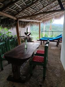 a wooden table and chairs under a roof with a table and chairs at villa vue mer - piscine privée in Las Terrenas