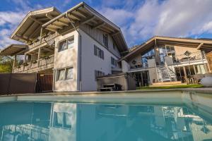 a house with a swimming pool in front of it at Alpenglühn Apartments - Adult Only in Berchtesgaden