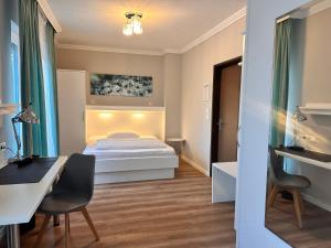 a small bedroom with a bed and a desk and a desk at Hotel Villa Solln - free parking in Munich