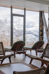 une pièce avec deux chaises et une grande fenêtre dans l'établissement Pine Hotel & Spa Brezovice, à Brezovicë