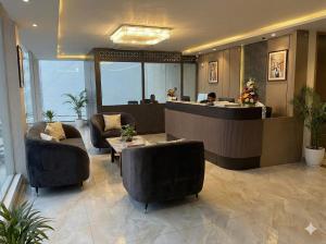 a lobby of a hotel with chairs and a counter at Hotel Grand Central Mysore in Mysore