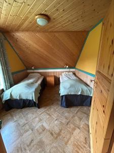two beds in a room with a wooden ceiling at Sognefjorden-Vik i Sogn in Brekka