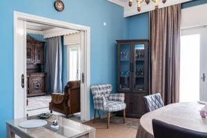 a living room with blue walls and a table and chairs at Elena's House in Polístilon