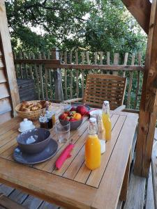 a wooden table with food and drinks on it at Aura Cabana - Cabane spa perchée à 6 m de haut in Saint-André-dʼOlérargues