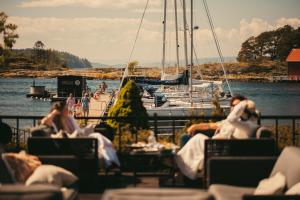 a group of people sitting on chairs near a marina at Son Spa in Son