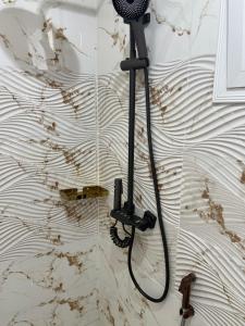a shower with a hose attached to a wall at FASA RESIDENCE Dakar CHAMBRE TERANGA in Dakar +15 photos