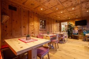 a dining room with wooden walls and tables and chairs at Hotel La Montanina in Livigno