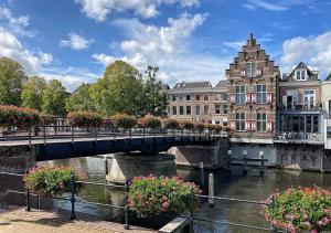 a bridge over a river with flowers and buildings at B and B Suite No.3 in Gorinchem
