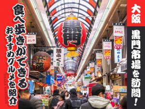 a crowd of people walking through a market with signs at 大阪難波ELLY-ten in Osaka