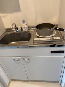 a kitchen with a sink and a pan on a counter at 大阪難波ELLY-ten in Osaka