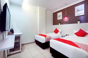 a hotel room with two beds and a flat screen tv at OYO 761 City Hotel in Kuala Lumpur +51 photos