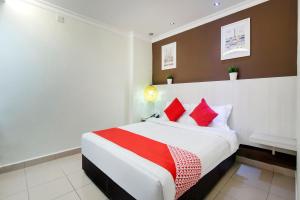 a bedroom with a large bed with red pillows at OYO 761 City Hotel in Kuala Lumpur