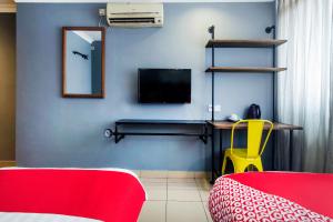 a room with a tv and a bed and a yellow chair at OYO 761 City Hotel in Kuala Lumpur