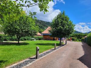 a road in front of a house with trees at Chalet Cocoon 6p avec Spa privé in Rochesson +7 photos