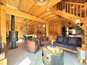 a living room with a couch and a table in a cabin at Chalet Cocoon 6p avec Spa privé in Rochesson