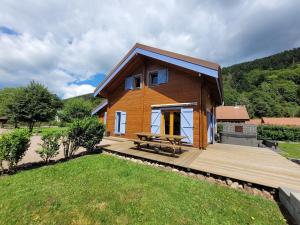 a house with a picnic table on a wooden deck at Chalet Cocoon 6p avec Spa privé in Rochesson