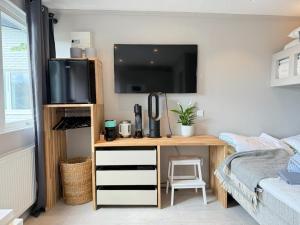 a bedroom with a desk with a tv and a bed at Siam Homestay 2 in Mölndal
