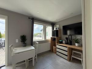 a living room with a table and a desk and a television at Siam Homestay 2 in Mölndal +13 photos