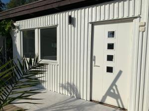 a white garage with a door and a window at Siam Homestay 2 in Mölndal