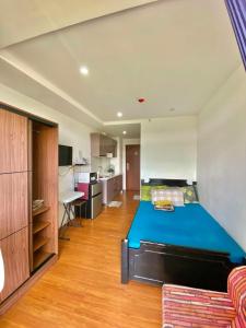 a bedroom with a blue bed and a kitchen at 8F-08 Overlooking Condo at Megatower 3 in Baguio