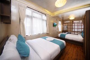 a small room with two beds and a window at Tibet Boutique Hotel Annex in Kathmandu +31 photos