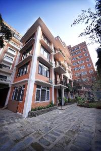a large brick building with a lot of windows at Tibet Boutique Hotel Annex in Kathmandu