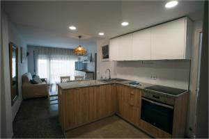 a kitchen with a sink and a stove top oven at Apartamento Floral al centro de Palamós con Wi-Fi in Palamós