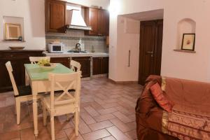 a kitchen and dining room with a table and a couch at SCAPPO IN UMBRIA, nel vicolo in Amelia