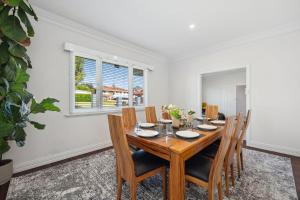 a dining room with a wooden table and chairs at Bedford Pool Oasis - Comfort near CBD & Airport in Perth