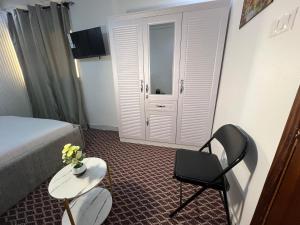 a hotel room with a bed and a table and a chair at FASA RESIDENCE Dakar CHAMBRE TERANGA in Dakar
