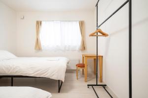 a bedroom with two beds and a window at 雪舞-YukiMai in Kutchan
