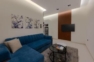 a living room with a blue couch and a table at المحروسة للشقق المفروشة Mahrousa Apartment in Medina