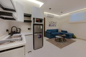 a kitchen and living room with a refrigerator and a couch at المحروسة للشقق المفروشة Mahrousa Apartment in Medina