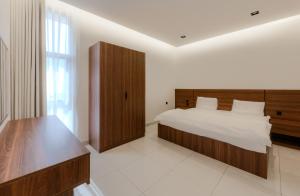a bedroom with a large bed and a wooden headboard at المحروسة للشقق المفروشة Mahrousa Apartment in Medina