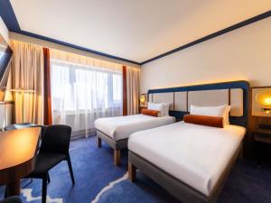 ein Hotelzimmer mit zwei Betten und einem Schreibtisch in der Unterkunft Mercure Gdynia Centrum in Gdynia + 127 Fotos