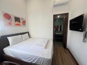 a bedroom with a bed and a flat screen tv at Nhã Hotel A in Thôn Mỹ Phước +50 photos