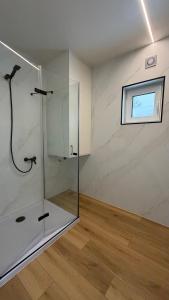 eine Glasdusche in einem Raum mit Fenster in der Unterkunft Odpocznij Podlasie in Łuka