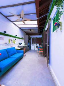 a living room with a blue couch and a ceiling fan at Coller Chinatown in Singapore