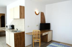 a small kitchen with a sink and a table with a chair at Hotel Oasis - Beach Access in Balchik