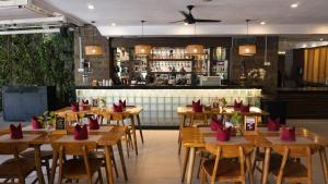 a restaurant with wooden tables with red napkins on them at Tusita Boutique Hotel in Kuta