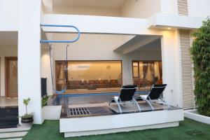 a view of a house with two chairs on a patio at Istrahtmas1 in Barka +1 photo