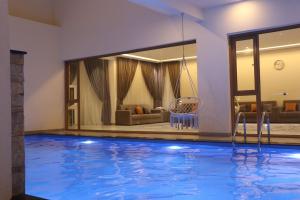 a swimming pool with a swing in a house at Istrahtmas1 in Barka