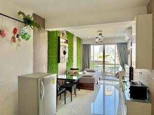 a kitchen and a living room with a refrigerator at Baan Sabai Rama IV Apartment in Bangkok