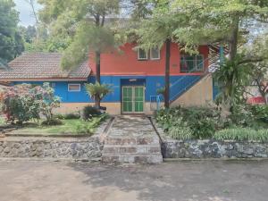a house with a red and blue paint on it at Villa Anyelir Yustik Mitra RedDoorz in Selabintana