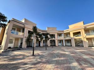 a large building with palm trees in the courtyard at Sanskar Resort in Pānāgar