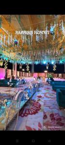 a large banquet hall with tables and chairs and chandeliers at Sanskar Resort in Pānāgar +13 photos
