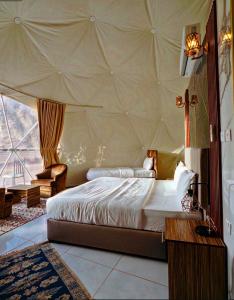 a bedroom with a large bed in a tent at Rum Four Seasons luxury Camp & Jeep Tours in Wadi Rum