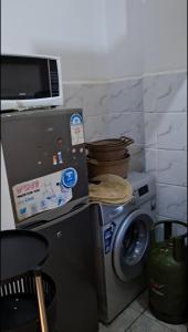a kitchen with a washing machine and a microwave at Sunny Studio Kikuyu Town in Kikuyu