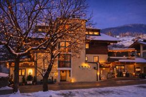 a building with christmas lights on it in the snow at Hotel Gasthof Kröll, 1x Großglockner kostenlos, Kinder bis 12 Jahre frei, Restaurant mit regionaler Küche in Niedernsill
