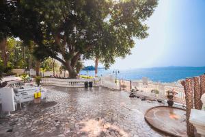 a cobblestone street with a tree and a body of water at Sky beach view in North Pattaya